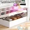 A white bed with storage compartments and an open storage area revealing pillows and folded blankets. The bed has a built-in shelf unit with LED lighting. Produktbild-Vorschau