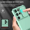 A hand is shown sliding the camera cover on a turquoise phone case. Produktbild-Vorschau