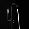 A black bathtub faucet with a handheld showerhead against a black background. Water is flowing from the faucet. Produktbild-Vorschau