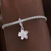 A close-up shot of a silver bracelet with a pink and white flower charm. Produktbild-Vorschau