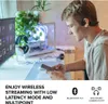 A young man is using headphones while looking at his phone, with a computer setup in the background. Náhľad obrázku produktu