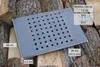 A rectangular grate with many holes, placed on a pile of firewood. Produktbild-Vorschau