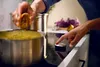 A person is cooking on an induction stove. Voir les images du produit