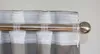 A close-up view of a curtain rod with a sheer white voile curtain attached. Produktbild-Vorschau