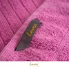 A close-up of a pink towel with a gray tag showing the brand name. Produktbild-Vorschau