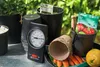 Gardening supplies including pots, seeds, soil, carrots, a thermometer, and a small shovel. Produktbild-Vorschau
