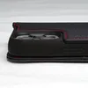 Close-up side view of a black leather phone case with red stitching. Produktbild-Vorschau