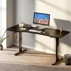A modern black adjustable standing desk with a computer, keyboard, mouse, and headphones. Náhled obrázku produktu