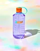 A purple Nalgene water bottle with an orange cap and teal loop is placed on a colorful, textured surface. Produktbild-Vorschau