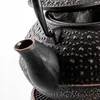 Close-up view of a black cast iron teapot with a textured surface and a spout. Podgląd zdjęcia produktu