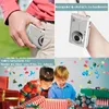 A collage of images showing a compact camera being placed in a pocket, a camera on a wrist, and two children opening presents. Produktbild-Vorschau