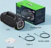 A product shot of a portable speaker and its packaging, along with included accessories like cables and a manual. Produktbild-Vorschau