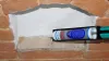 A close-up view of a tube of silicone sealant being applied to a brick wall. Anteprima dell’immagine prodotto