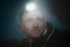 A close-up shot of a man wearing a headlamp in the dark. Anteprima dell’immagine prodotto