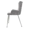 A side view of a gray upholstered dining chair with tufted detailing and silver metal legs, isolated on a white background. Produktbild-Vorschau