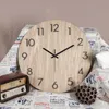 A wooden wall clock is displayed on a surface covered with newspaper-like fabric, alongside a vintage radio and a dried lotus seed pod. Anteprima dell’immagine prodotto