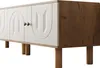 A modern sideboard with white doors and wooden legs, shown from a side angle. Produktbild-Vorschau