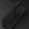 A black phone case with a textured surface and a sliding camera cover is shown on a dark, textured surface. Náhled obrázku produktu