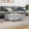 A modern living room scene with a gray sectional sofa, a concrete-look coffee table, and a potted plant. Voir les images du produit
