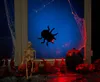 Halloween decorations on a windowsill, including a skeleton, spider, and pumpkin, with red lighting. Produktbild-Vorschau