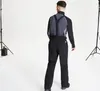 A man wearing ski pants and a jacket, viewed from the back, in a studio setting with lighting equipment. Voir les images du produit