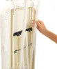 A hand is shown holding a white tube attached to the side of an ironing board. Voir les images du produit