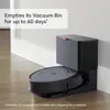 A robot vacuum cleaner docked in its charging and dirt disposal station, with text overlay describing its features. Voir les images du produit