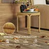 A rattan side table with a glass top is placed on a wooden deck, with a vase of flowers and a fruit bowl on top. Fallen leaves are scattered around the table. Podgląd zdjęcia produktu