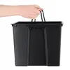 A person's hands holding the handles of a black plastic planter. Podgląd zdjęcia produktu