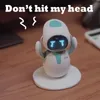 A small, white robot with blue accents and a digital face is shown on a wooden desk, with wavy lines above its head and text that reads 'Don't hit my head'. Náhled obrázku produktu