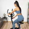 A woman is using a stationary exercise bike in a home gym setting. Náhľad obrázku produktu