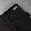 Close-up of the interior of a black leather phone case with red stitching. Produktbild-Vorschau