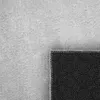 A close-up view of a rug, showing the texture of the top and the patterned underside. Produktbild-Vorschau