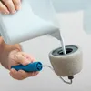 A person is pouring white paint into a paint roller. Voir les images du produit