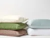 A stack of pillows in various colors against a white background. Produktbild-Vorschau