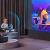 A young boy sits on a couch watching a projection from a projector. The projection displays a colorful animated scene. Anteprima dell’immagine prodotto