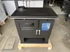 A black wood-burning stove is displayed in what appears to be a warehouse or storage area, resting on a wooden pallet. Produktbild-Vorschau
