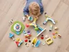 A child playing with LEGO DUPLO toys on a wooden floor. Podgląd zdjęcia produktu