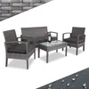 A grey rattan furniture set with dark grey cushions, including two armchairs, a loveseat, and a coffee table with a glass top. A bottle of wine and two glasses are on the table. Produktbild-Vorschau