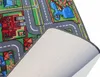 A close-up view of a children's play mat with a city street design, showing the top surface and the underside of the mat. Produktbild-Vorschau