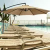 A row of lounge chairs next to a swimming pool, with a large cantilever umbrella providing shade. Produktbild-Vorschau
