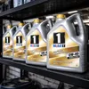 Several bottles of Mobil 1 oil lined up on a shelf. Produktbild-Vorschau