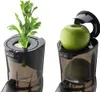 A split image showing the top part of a juicer with celery in one half and an apple in the other. Podgląd zdjęcia produktu