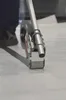 A close-up shot of a tape dispenser applying silver-grey tape to a white surface. Produktbild-Vorschau