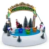 A miniature Christmas scene featuring a rotating coffee cup ride with Santa, a snowman, and other festive elements. Náhled obrázku produktu