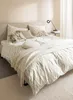 A neatly made bed with patterned bedding and several decorative pillows, a throw blanket draped over it, and a bedside lamp on a small table. Anteprima dell’immagine prodotto
