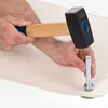 A person's hands are shown using a hammer to strike a metal punch tool onto a piece of fabric. Produktbild-Vorschau