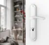 A close-up of a white door handle and lock mechanism on a white wall, with a blurred interior scene in the background. Produktbild-Vorschau