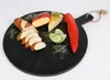 A round black serving board with food items on it. Anteprima dell’immagine prodotto