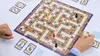 A board game is being played by two people. Produktbild-Vorschau